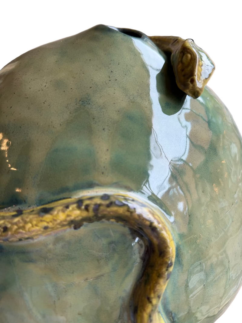 Close-up of a green ceramic vase with a textured surface