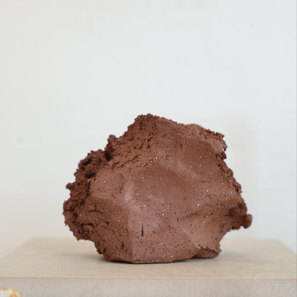Brown stoneware clay on a white surface with a blurred background