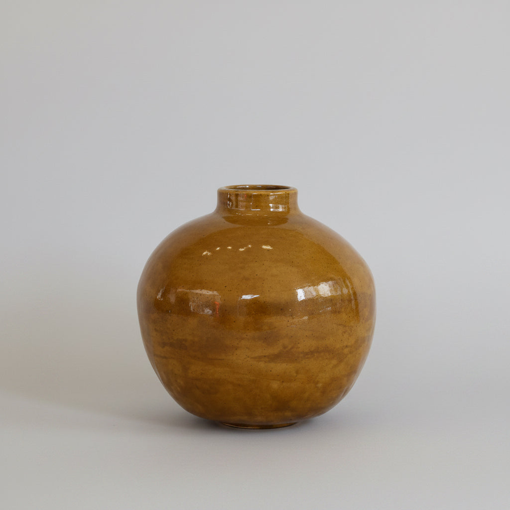 Laguna MS-17 Golden Green Glaze on 931 clay ceramic moon jar on a wooden surface with a white wall background